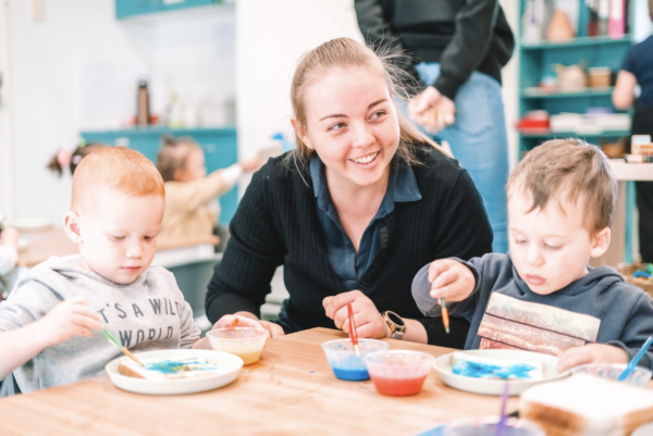 An educator painting with toddlers at Arden Early Learning Airlie Beach